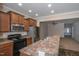 Kitchen view featuring stainless appliances, wood cabinets, large counter top, open to living area at 9805 Precious Stone Dr, Wake Forest, NC 27587