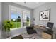 Bright office with a large window overlooking a beautiful green lawn, complemented by a modern glass desk and chair at 53 Merele Dr, Wendell, NC 27591