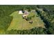 Aerial view of a stunning estate with lush greenery, equestrian facilities, and a serene pond at 1018 Terrell Woods Ln, Chapel Hill, NC 27516