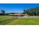 Equestrian facility boasting a pristine barn with multiple stalls, complemented by a grassy pasture and a clear blue sky at 1018 Terrell Woods Ln, Chapel Hill, NC 27516