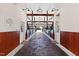 Spacious barn interior with brick flooring and multiple stalls leading to a view of the pasture at 1018 Terrell Woods Ln, Chapel Hill, NC 27516