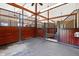 Interior of horse stables with wood beam ceiling, partial walls and gated stall doors at 1018 Terrell Woods Ln, Chapel Hill, NC 27516