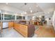 Open-concept kitchen features a center island with gas range, custom cabinetry, and seamless flow into the dining and living areas at 1018 Terrell Woods Ln, Chapel Hill, NC 27516