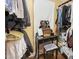 View of a walk-in closet with hanging clothes and a vanity and stool area for dressing and makeup at 111 Preakness Dr, Archer Lodge, NC 27527