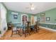 Green dining room with hardwood floors and a classic ceiling fan at 1303 Rainy St, Burlington, NC 27217