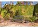 Secluded backyard nook featuring an ornate wrought iron bench against a vine-covered brick wall at 1414 Mahonia Ct, Raleigh, NC 27615