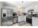 Well-lit kitchen with stainless steel appliances, white cabinets, and tile backsplash at 1414 Mahonia Ct, Raleigh, NC 27615