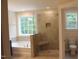 Modern bathroom showcasing a glass-enclosed shower, soaker tub, and a separate toilet area at 1414 Reading Ct # 91Kl, Burlington, NC 27217