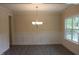 Dining room featuring wainscoting, modern chandelier, hardwood floors, and a large window at 1414 Reading Ct # 91Kl, Burlington, NC 27217