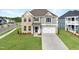 Charming two-story home featuring a two-car garage, well-manicured lawn, and classic architectural details at 15 Nimble Way # 175, Clayton, NC 27520