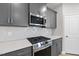 Modern kitchen featuring gray cabinets, stainless steel appliances, quartz countertops, and tiled backsplash at 15 Nimble Way # 175, Clayton, NC 27520