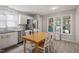 Well-lit kitchen features stainless steel appliances, white cabinets, and a table with chairs, next to a window to an outside view at 1721 Kingston Heath Way, Raleigh, NC 27604