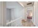 Upstairs hallway with white railing leads to bedrooms with light gray walls and light gray floors at 1721 Kingston Heath Way, Raleigh, NC 27604