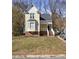 Charming yellow home features a welcoming porch, bay window, and well-maintained front yard at 1721 Kingston Heath Way, Raleigh, NC 27604