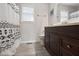 Well-lit bathroom featuring a dark wood vanity, shower with patterned curtain, toilet and a bright window at 1721 Kingston Heath Way, Raleigh, NC 27604