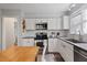 Modern kitchen with stainless steel appliances, granite countertops, and white cabinetry at 1721 Kingston Heath Way, Raleigh, NC 27604