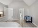 Neutral bedroom with vaulted ceilings, light gray walls and floors, and a view of the doorway to a hallway at 1721 Kingston Heath Way, Raleigh, NC 27604