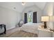 Bright bedroom with vaulted ceilings, gray walls, modern light fixture, and an arched window with curtains at 1721 Kingston Heath Way, Raleigh, NC 27604
