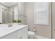 Well-lit bathroom featuring a white vanity, large mirror, and a tiled shower at 213 W Weatherford Dr, Angier, NC 27501