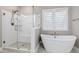Bright bathroom with a freestanding tub, walk-in shower, white subway tile, and a window for natural light at 213 W Weatherford Dr, Angier, NC 27501