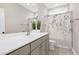 Well-lit bathroom featuring a modern vanity, large mirror, and a shower with decorative curtain at 213 W Weatherford Dr, Angier, NC 27501
