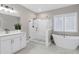 Bright bathroom with a glass-enclosed shower, soaking tub, and white vanity at 213 W Weatherford Dr, Angier, NC 27501