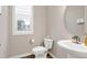 Bathroom featuring a white toilet, sink with unique faucet, and a window providing natural light at 213 W Weatherford Dr, Angier, NC 27501