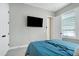 Bedroom showcasing a wall-mounted TV and a stylish blue bedspread on plush carpeting at 213 W Weatherford Dr, Angier, NC 27501