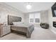 Primary bedroom showcases a modern lighting fixture, a dresser, and a window at 213 W Weatherford Dr, Angier, NC 27501