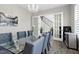 Modern dining area featuring large glass table, sophisticated chandelier, and gray upholstered chairs at 213 W Weatherford Dr, Angier, NC 27501