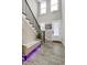 Bright foyer featuring stairs, a tufted storage bench, and dark hardwood floors at 213 W Weatherford Dr, Angier, NC 27501