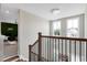 Upstairs view of a foyer with modern chandelier and staircase, looking toward a room with a distinctive moss wall at 213 W Weatherford Dr, Angier, NC 27501
