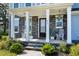 Inviting front porch with stone pillars, rocking chairs, and well-manicured landscaping at 213 W Weatherford Dr, Angier, NC 27501