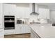 Modern kitchen with stainless steel appliances, white cabinetry, and a stylish range hood at 213 W Weatherford Dr, Angier, NC 27501