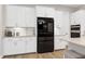 Elegant kitchen with white cabinets, black refrigerator, and stainless steel appliances at 213 W Weatherford Dr, Angier, NC 27501