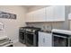 A well-equipped laundry room features modern appliances, ample cabinetry, and a practical sink area at 213 W Weatherford Dr, Angier, NC 27501