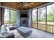 Inviting screened porch with stone fireplace, ceiling fan, and comfortable seating, perfect for outdoor living at 213 W Weatherford Dr, Angier, NC 27501