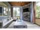 Relaxing screened porch with fireplace, TV, and stylish outdoor furniture at 213 W Weatherford Dr, Angier, NC 27501