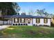 Charming brick home features manicured lawn, black trim, covered carport and inviting front porch at 226 Pinecroft Dr, Raleigh, NC 27609