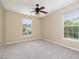 Carpeted bedroom with two windows, cream walls and a ceiling fan at 3009 Winston Dr # 90, Burlington, NC 27215