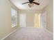 A carpeted bedroom featuring neutral walls, a ceiling fan, window, and three doors at 3009 Winston Dr # 90, Burlington, NC 27215