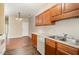 Bright kitchen featuring wood cabinets, laminate countertops, stainless steel sink, and hardwood floors at 3009 Winston Dr # 90, Burlington, NC 27215
