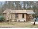 Charming single-story home with tan siding, a cozy porch, and landscaped front yard nestled in a wooded setting at 3711 Shrewsbury St, Durham, NC 27707