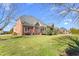 Expansive backyard with lush green lawn and a charming brick home with a screened-in porch at 4270 Aviemore Run, Burlington, NC 27215