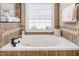 Bright bathroom with a large soaking tub, tile backsplash, and bronze fixtures under a window at 4270 Aviemore Run, Burlington, NC 27215