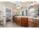 Bathroom with double vanity sinks, granite countertop, dark wood cabinets, and view into bedroom at 4270 Aviemore Run, Burlington, NC 27215