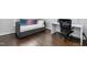 Bedroom with dark hardwood floors, a pull-out couch with decorative pillows, and a desk workspace at 4270 Aviemore Run, Burlington, NC 27215