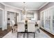 Bright dining room showcasing a chandelier, large windows, and seamless transition to the kitchen at 4270 Aviemore Run, Burlington, NC 27215