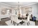 Elegant dining room with a chandelier, silver wallpaper, and an adjoining living room at 4270 Aviemore Run, Burlington, NC 27215