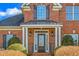 Elegant red brick home showcasing a classic front door with sidelights and manicured landscaping at 4270 Aviemore Run, Burlington, NC 27215